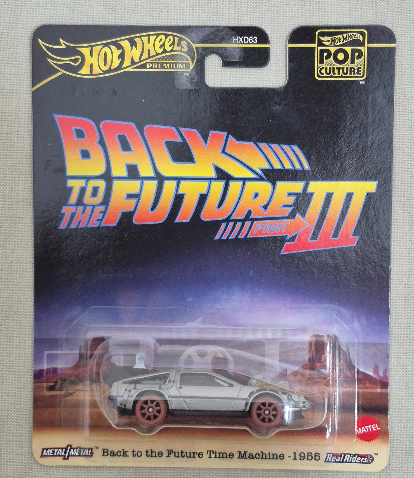 Back to the Future III Hot Wheels toy car in packaging on a textured surface