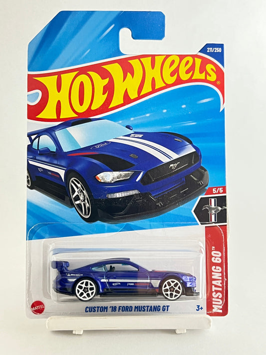 Hot Wheels toy car packaging with a blue and white Mustang GT on a beige background