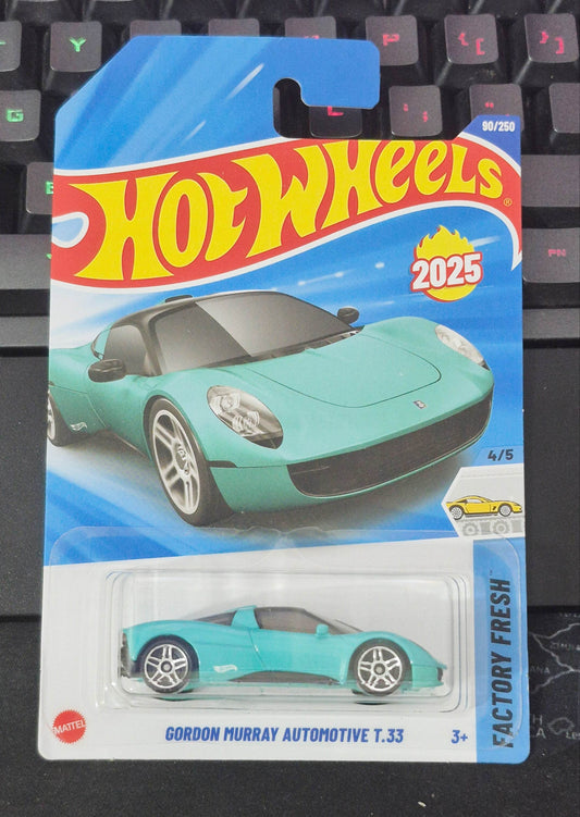 Hot Wheels toy car in packaging on a keyboard